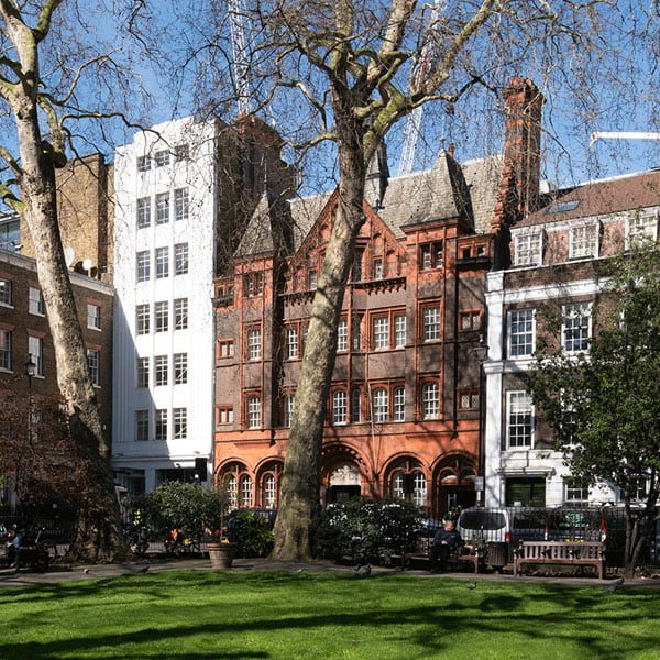 Historic buildings surrounding Soho Square's central green space in London