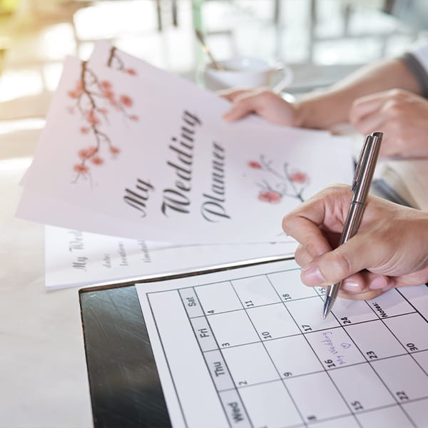 Planning wedding finances Wedding planner reviewing budget spreadsheet and venue options for bride's celebration