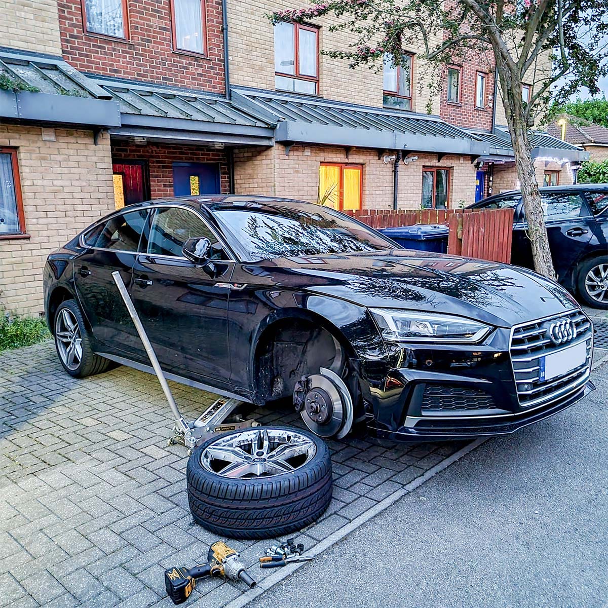 Professional technician inspecting car tyre during mobile fitting service
