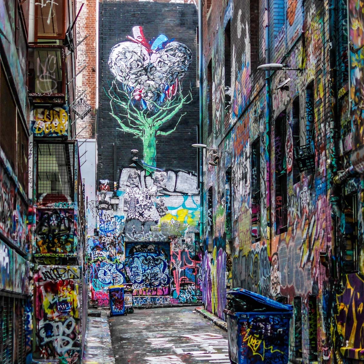 Soho street artist creating colourful mural artwork on urban brick wall