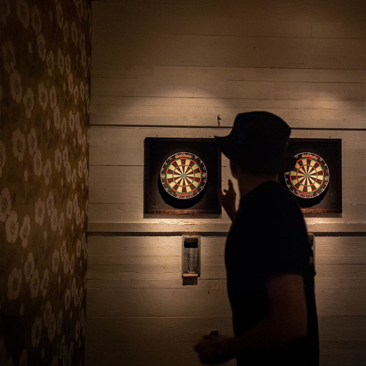 a person shooting darts to a board