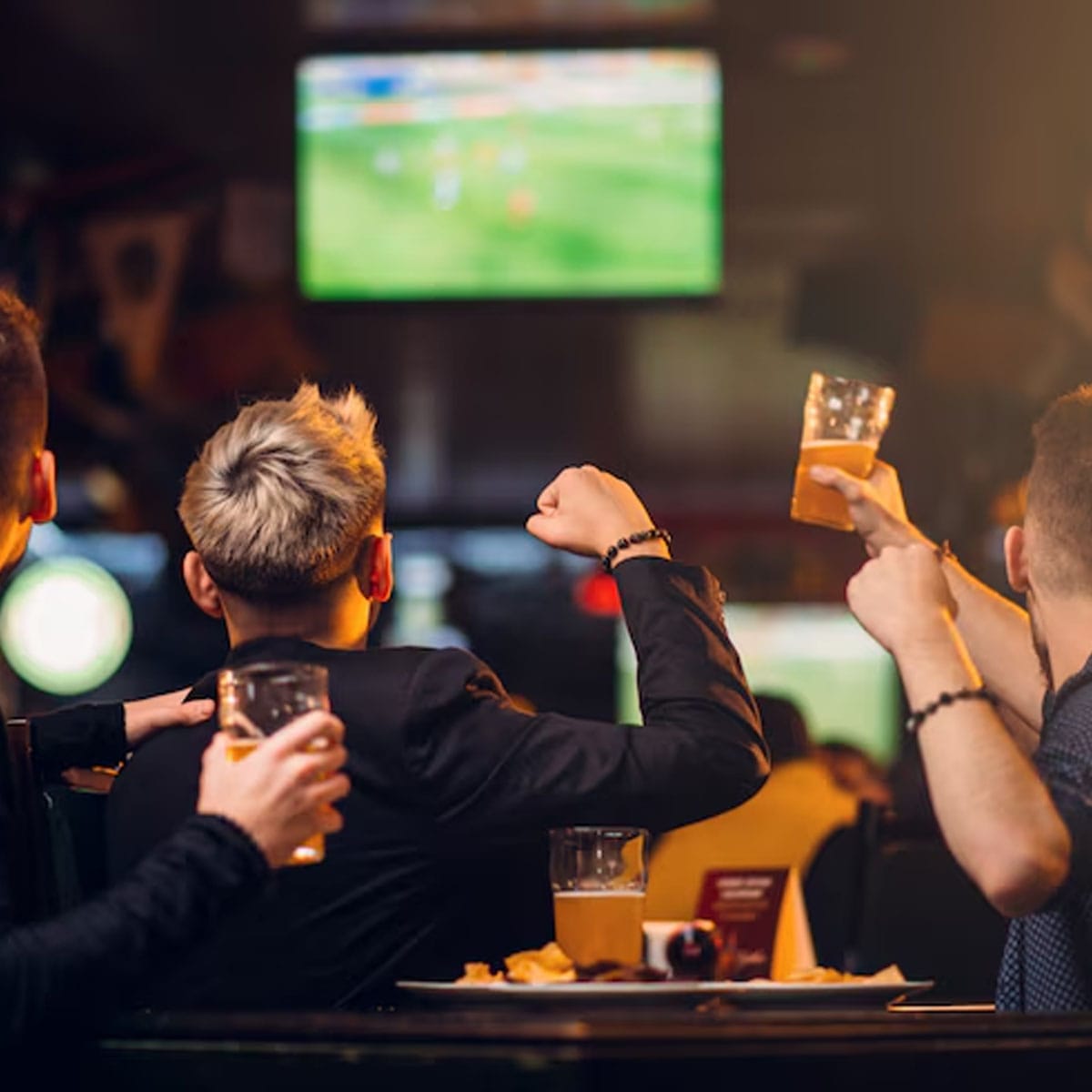 Community spirit through sports betting Sports fans gathered in Soho pub discussing match odds and celebrating wagered outcomes together