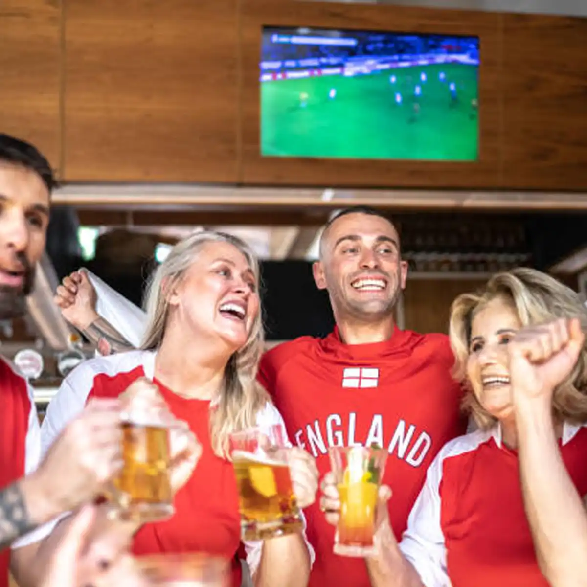 Diverse crowd of football fans gathered together in Soho venue supporting different teams