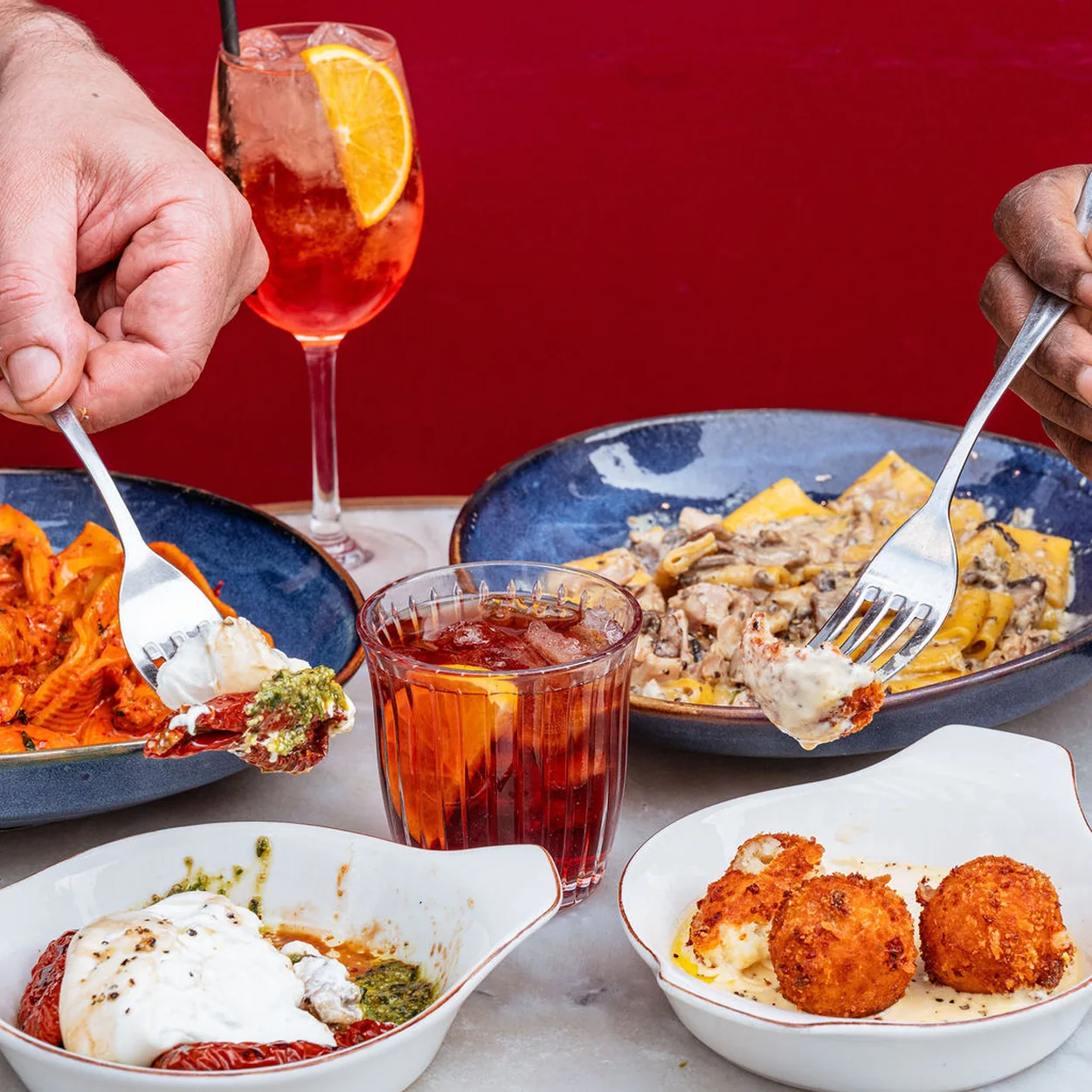 Table spread of pasta, meatballs, burrata and spritz cocktails at 27 Old Compton Street in Soho