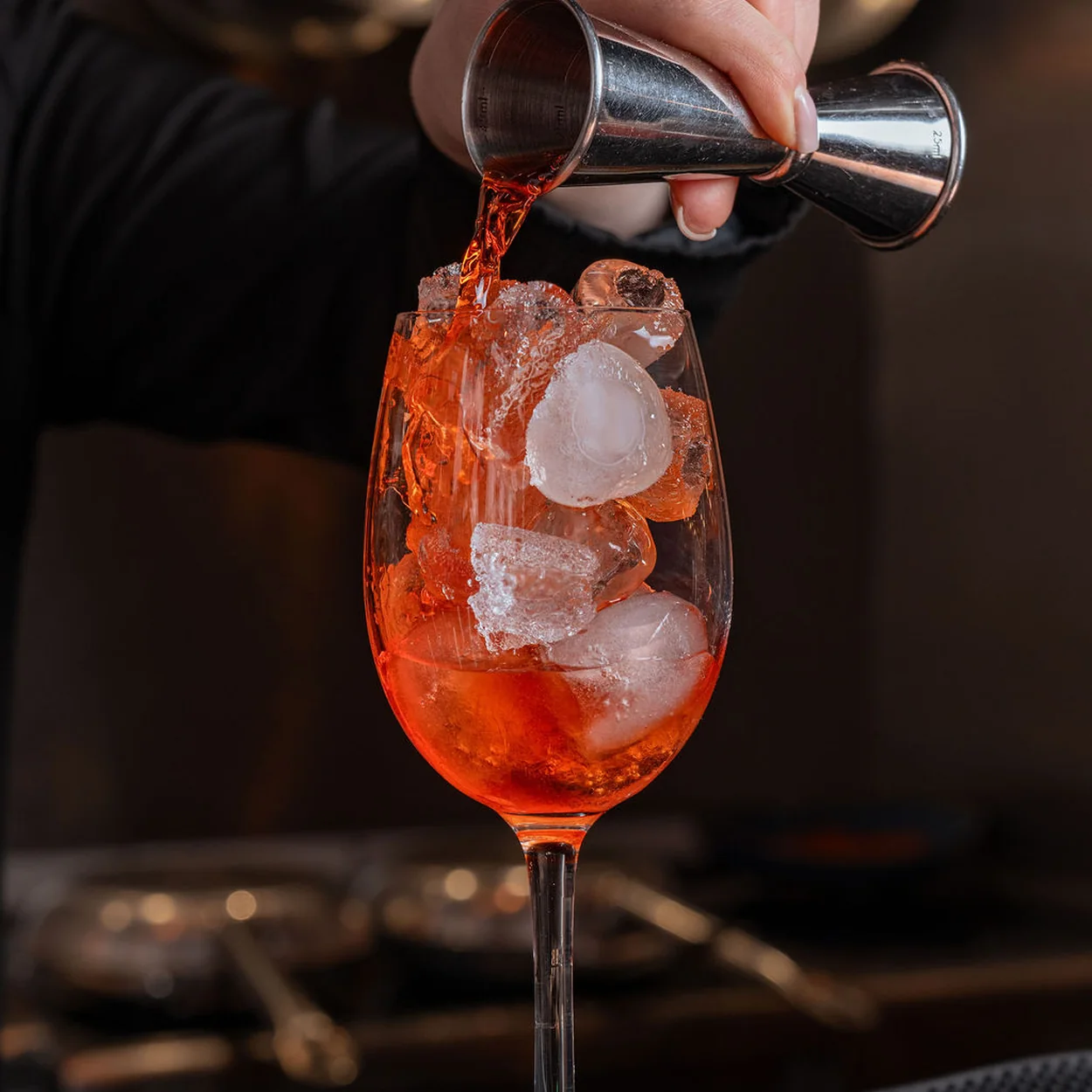 Bartender pouring an Aperol spritz over ice at 27 Old Compton Street restaurant in Soho
