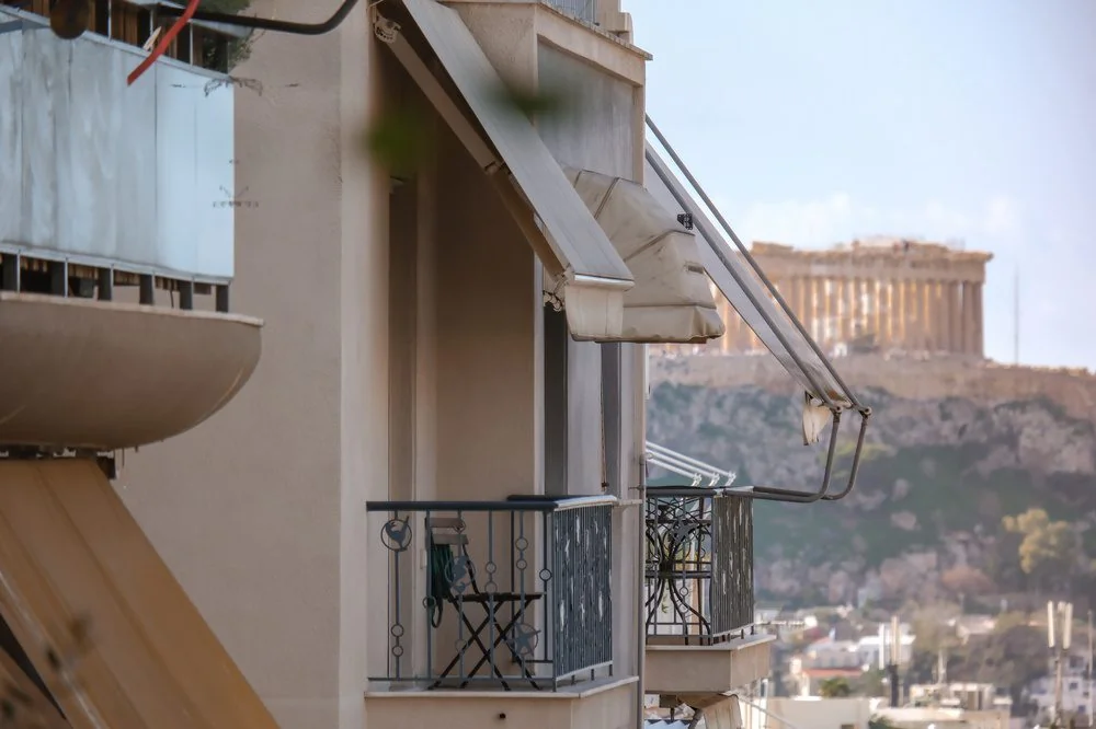 Athens apartment balconies with the Acropolis in the background, illustrating residential property in Attica