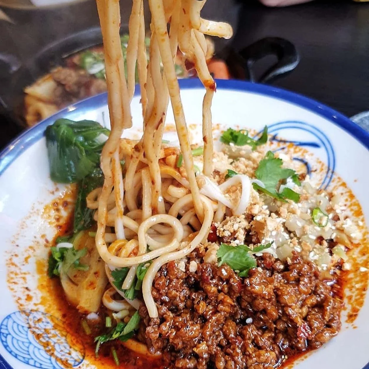 Biang biang noodles pulled from a bowl of minced pork and chilli at Baozi Inn Soho