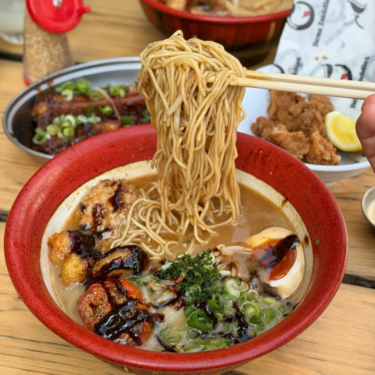 Lifting noodles from a tonkotsu ramen bowl at Bone Daddies on Old Compton Street