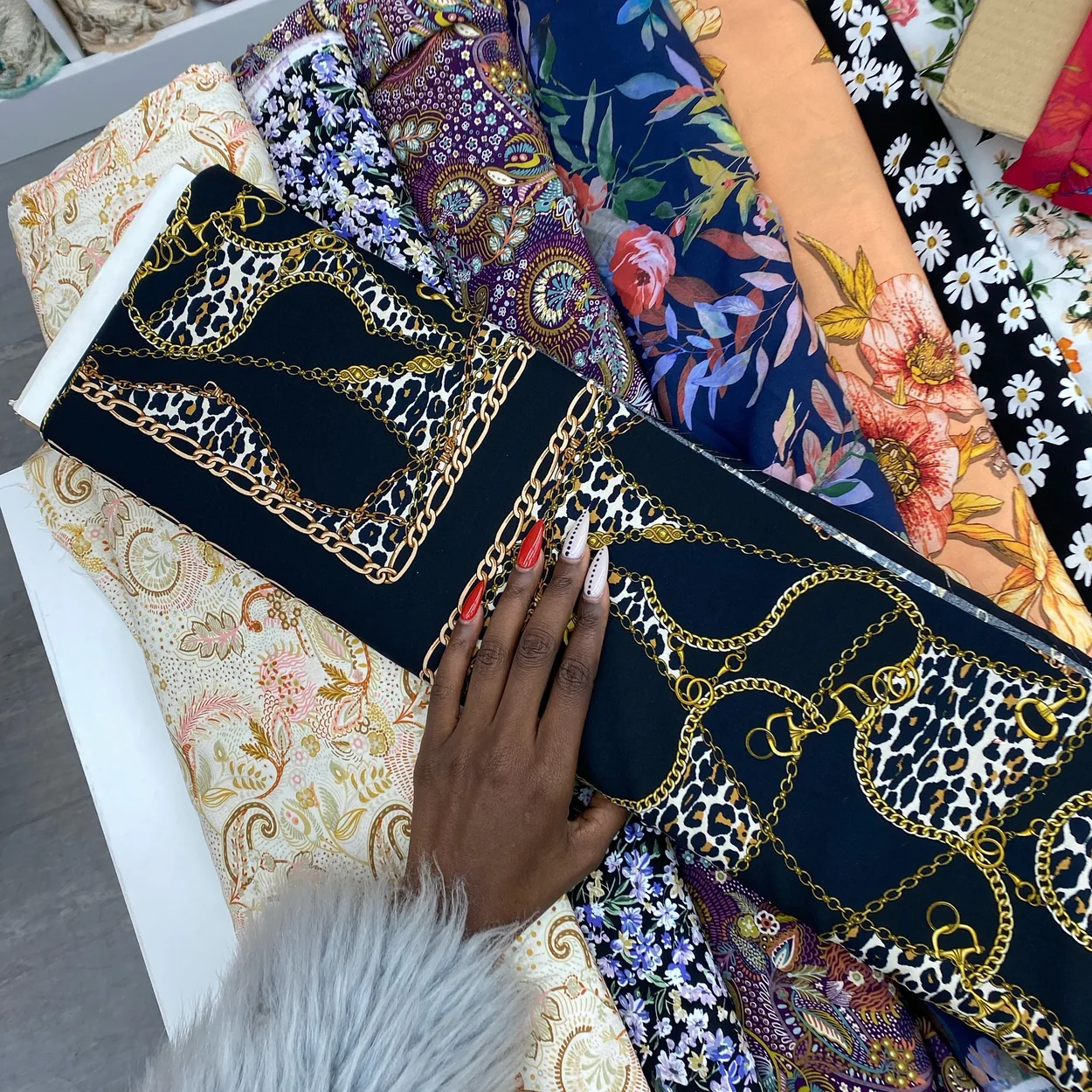 Printed dress fabrics fanned out on the counter at Borovick Fabrics in Soho