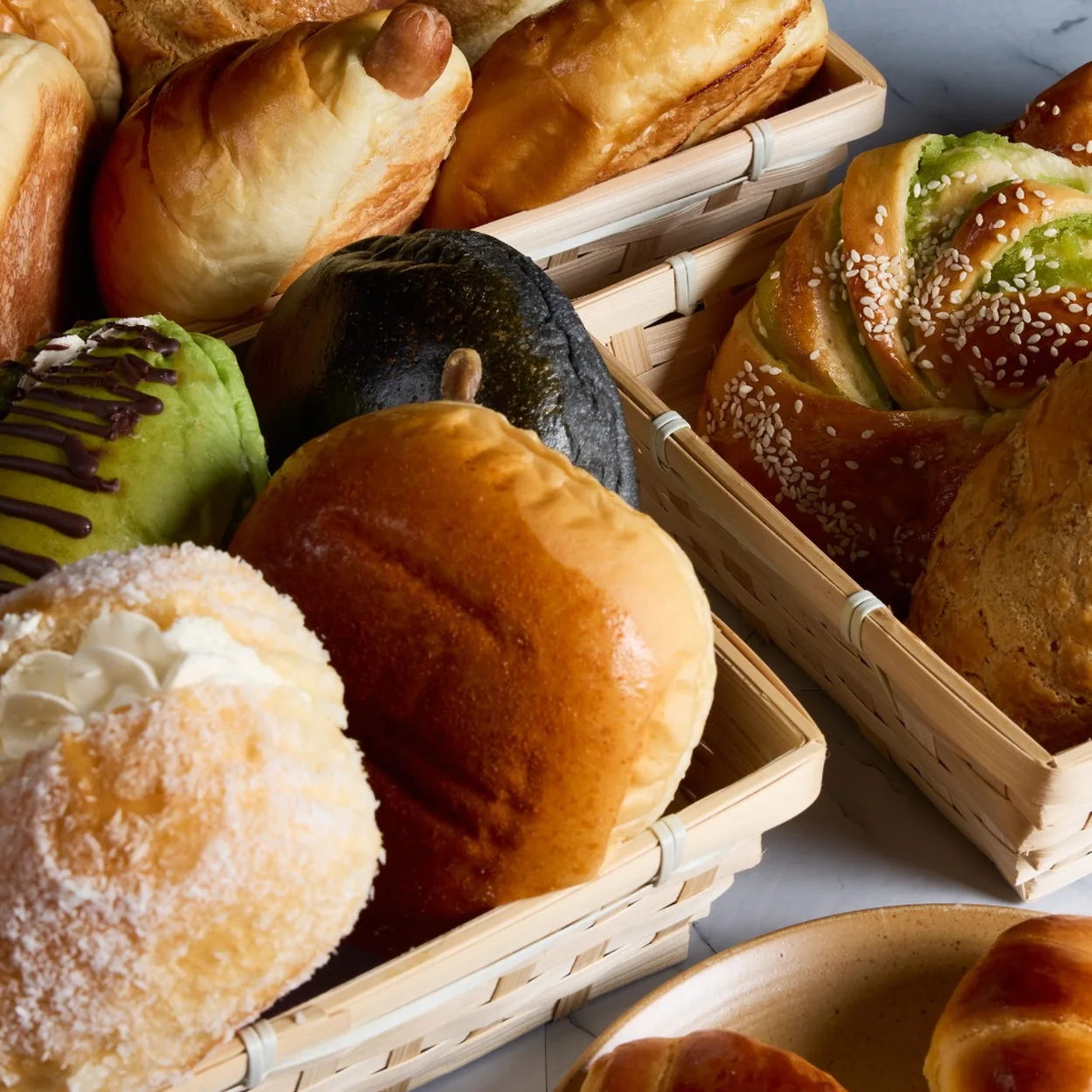 Baskets of fresh buns and pastries on the counter at Chinatown Bakery on Newport Place