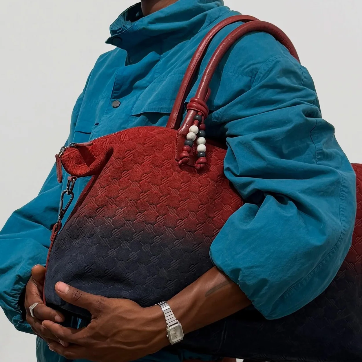 Model carrying a two-tone Daily Paper monogram tote from the label's collection