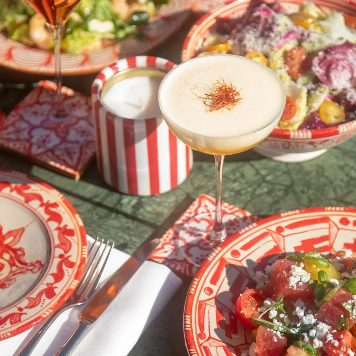 Cocktail and colourful plates laid on patterned china at Dear Jackie in Broadwick Soho