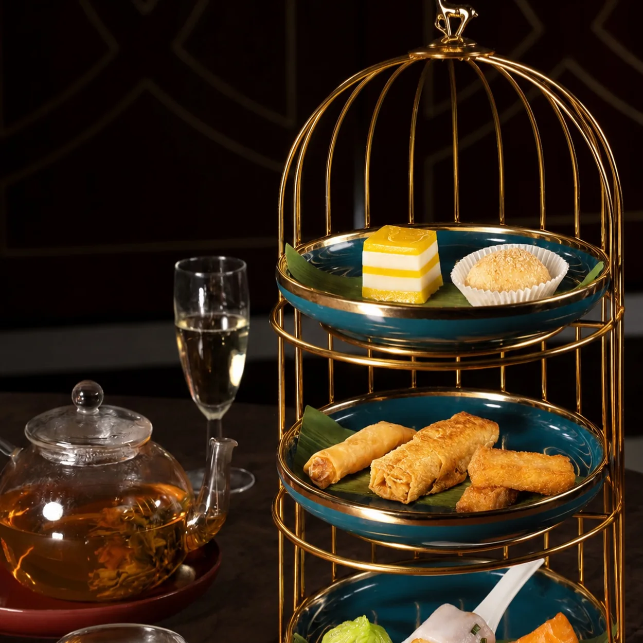 Gilded birdcage afternoon tea stand with dim sum and pastries at Golden Phoenix