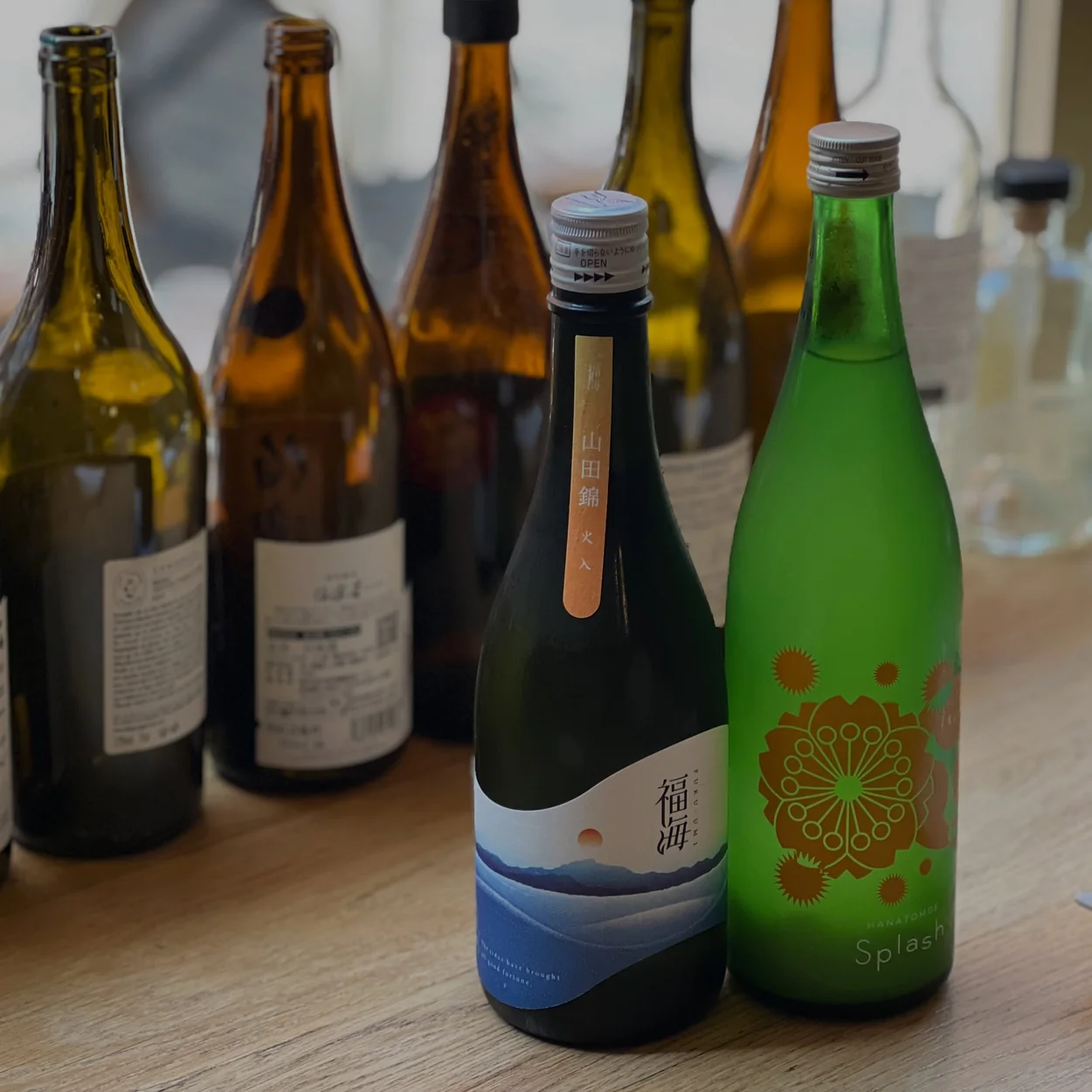Selection of sake bottles lined up on the counter at HIMI Soho