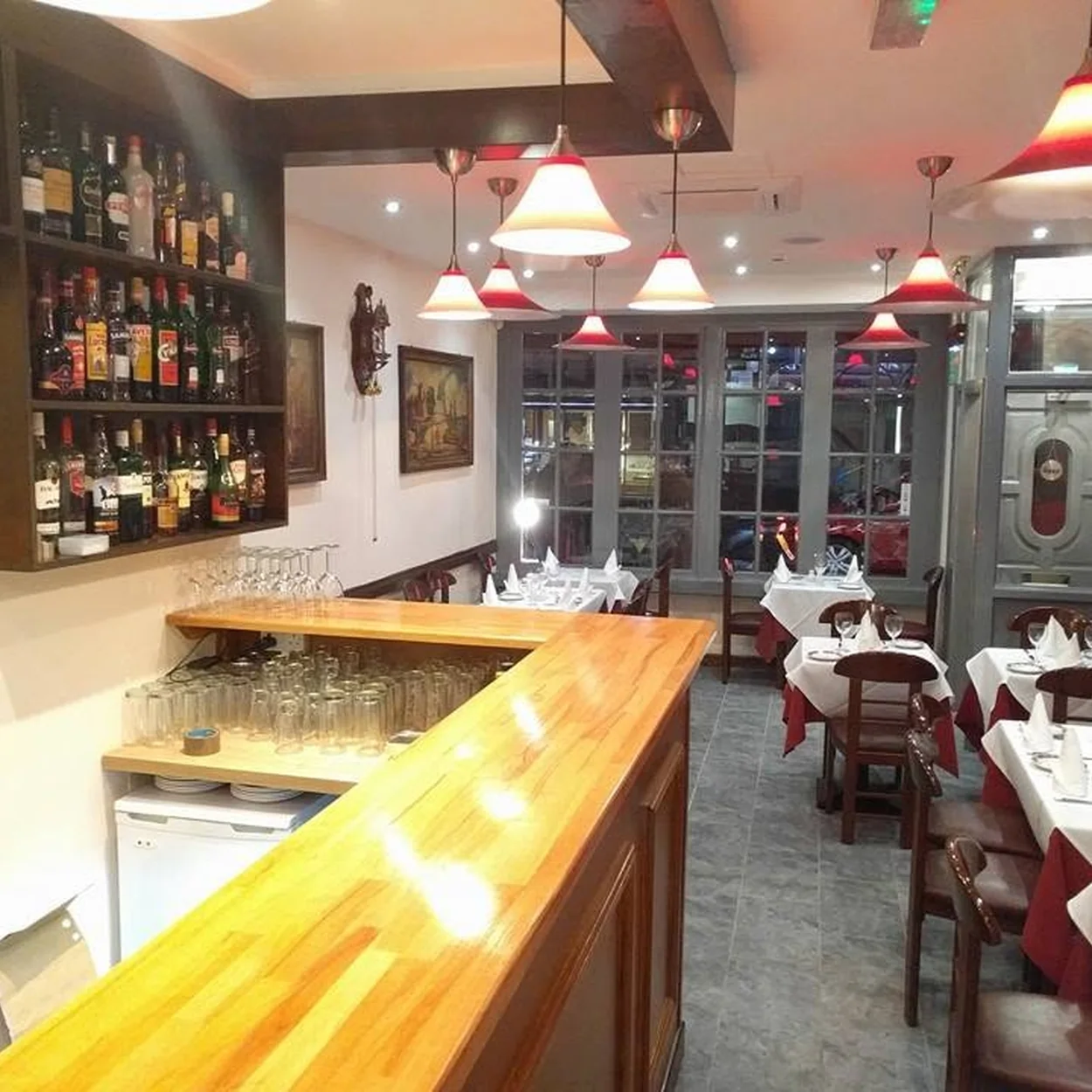 White-clothed tables and the wooden bar inside Il Cucciolo, the Old Compton Street trattoria