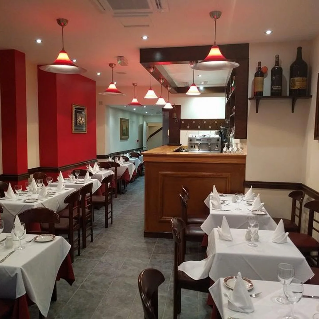 Red-walled dining room set with folded napkins at Il Cucciolo in Soho