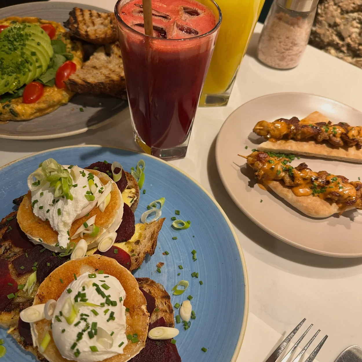 Brunch table with eggs benedict, skewers and fresh juices at My Place Soho