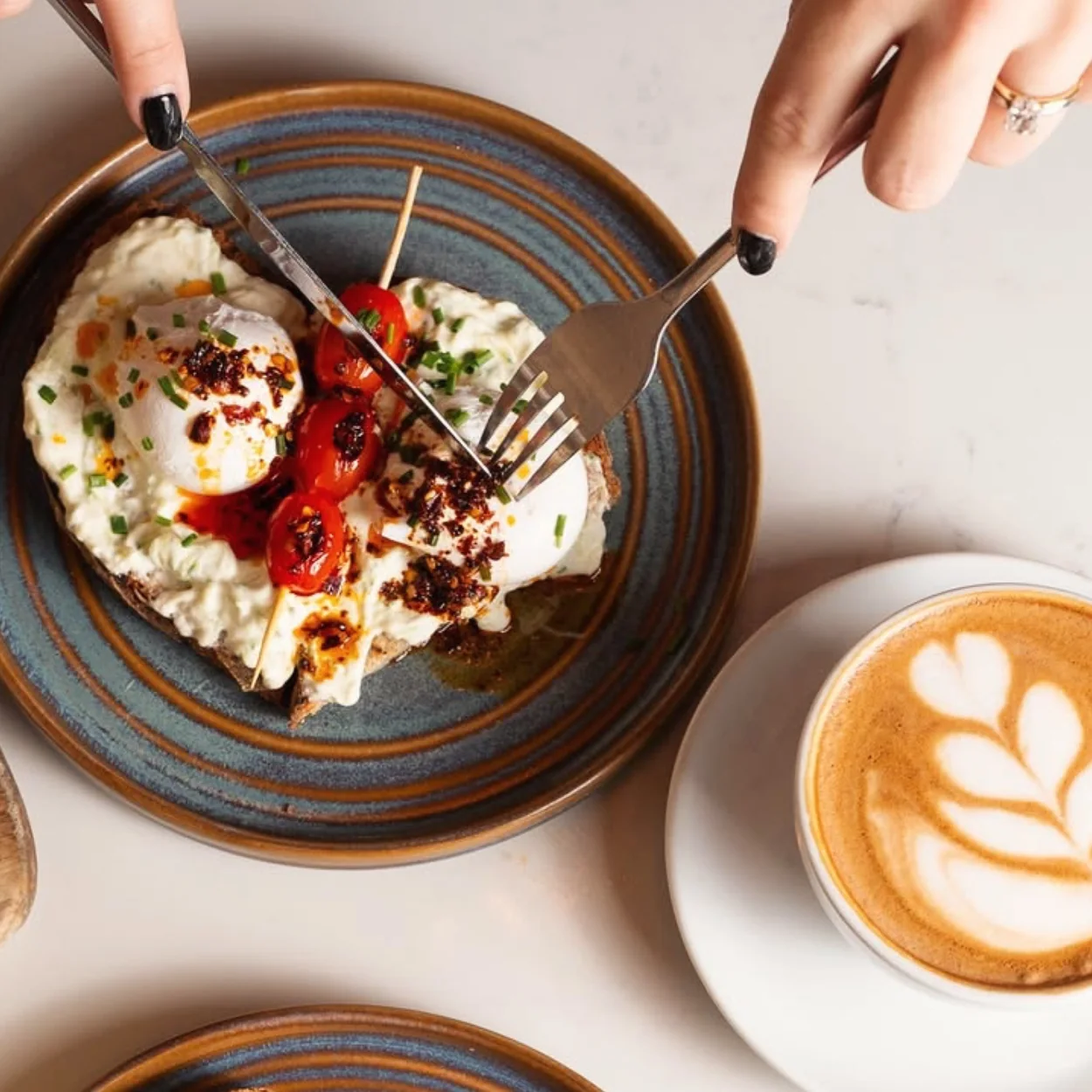 Turkish eggs with chilli butter beside a flat white at My Place Soho