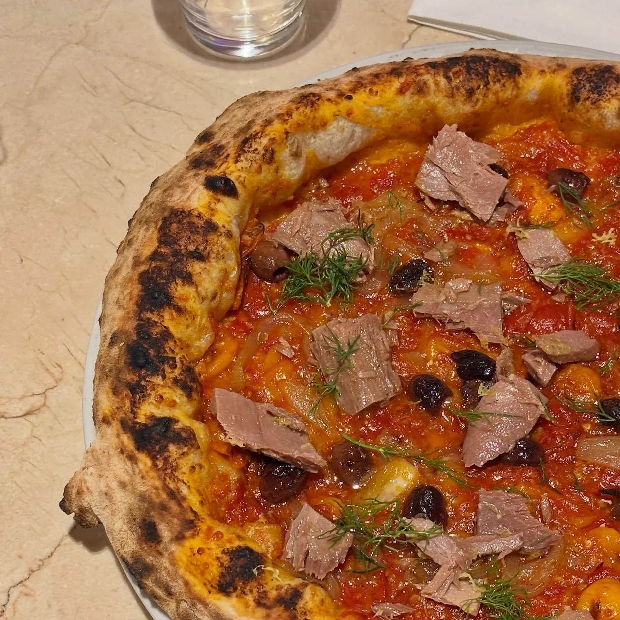 Neapolitan pizza topped with cured beef and olives at Napoli on the Road