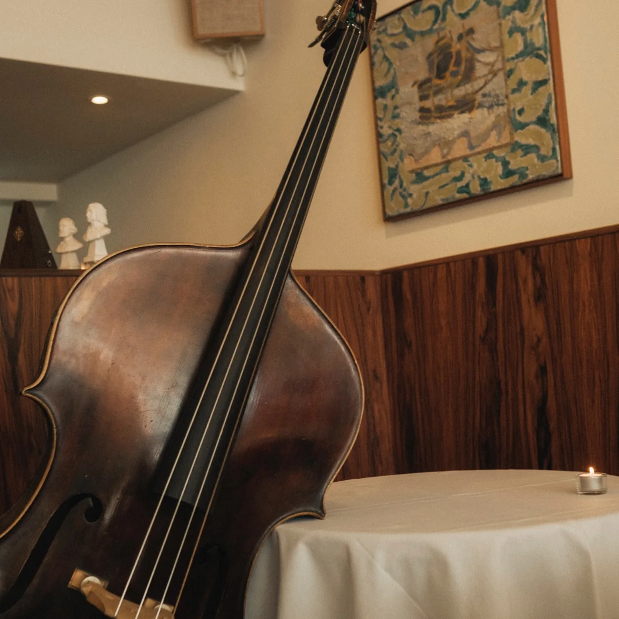 Double bass resting beside a set table at Osteria Vibrato, Soho's musical osteria