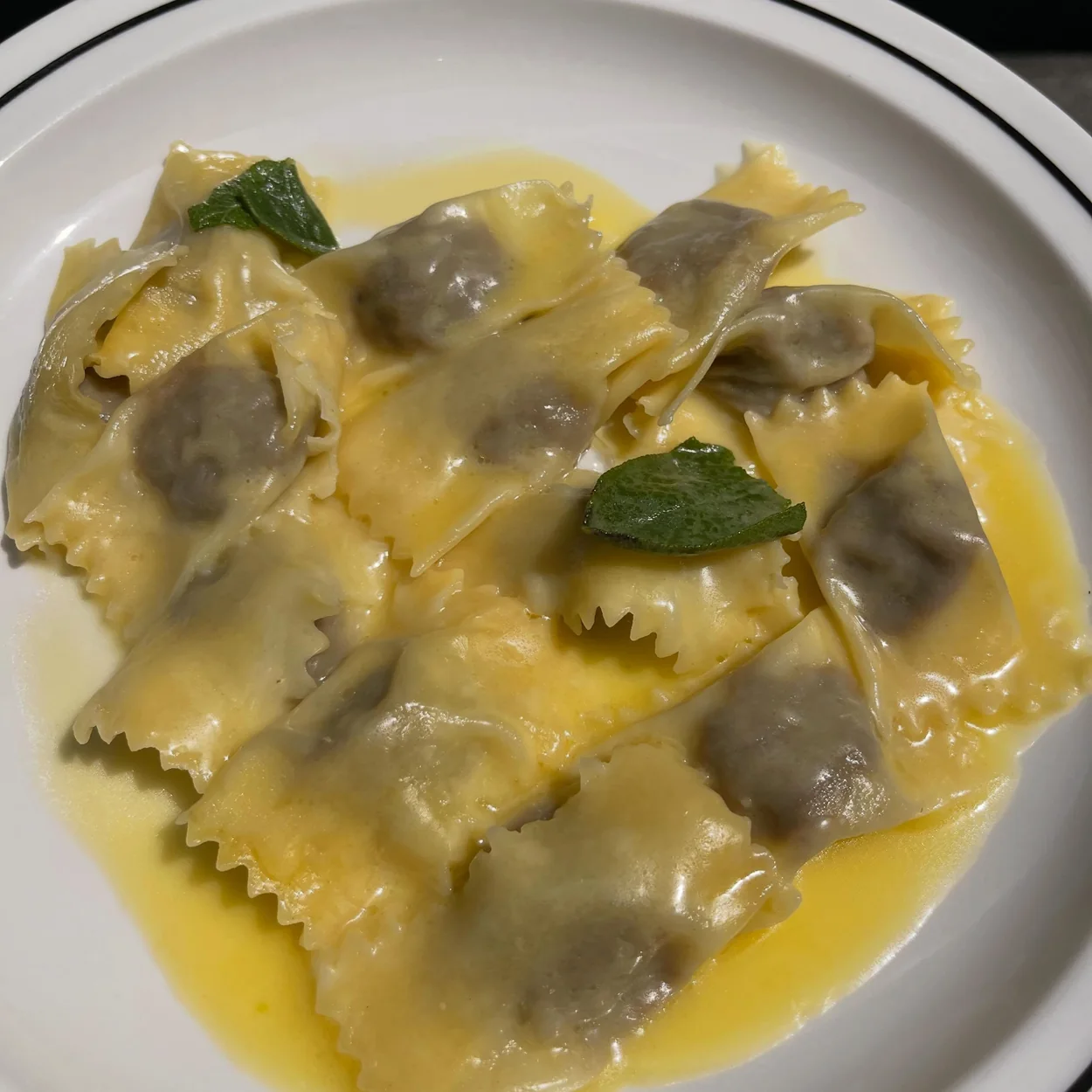 Mint-topped ravioli in burnt butter on a Padella crested plate at the Soho pasta bar