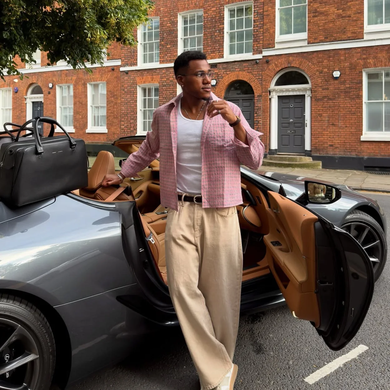 Percival lookbook outfit with pink overshirt photographed beside a sports car