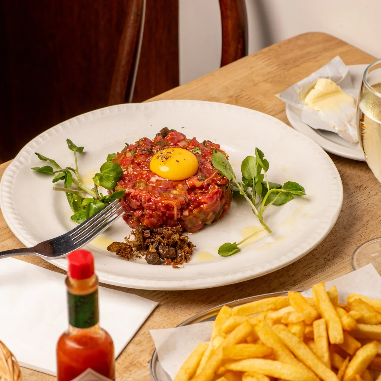 Steak tartare with egg yolk and frites on the table at Prix Fixe on Dean Street