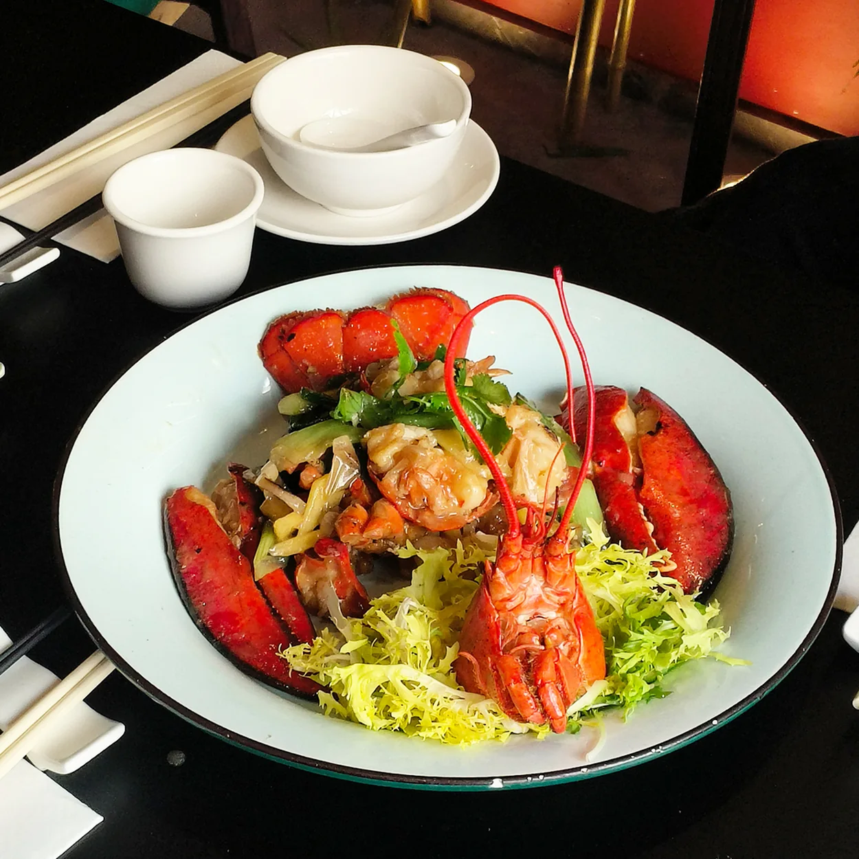 Whole lobster with frisee salad plated on green ceramics at Royal China in Chinatown