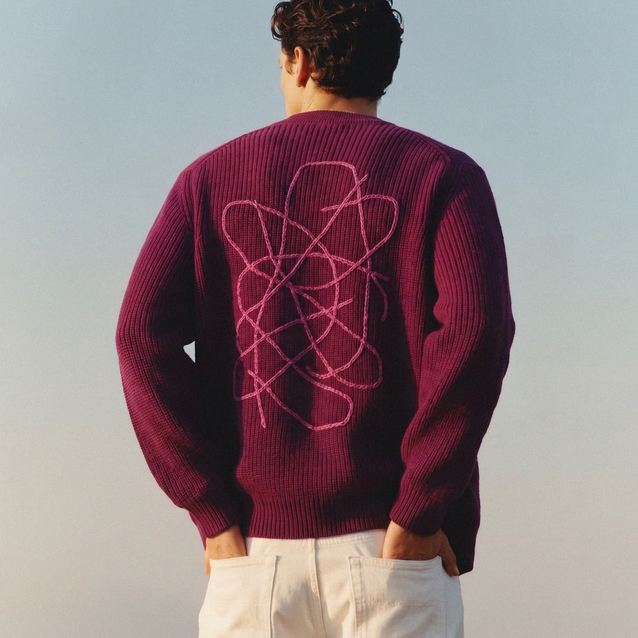 Back of a magenta Sheep Inc jumper with embroidered motif