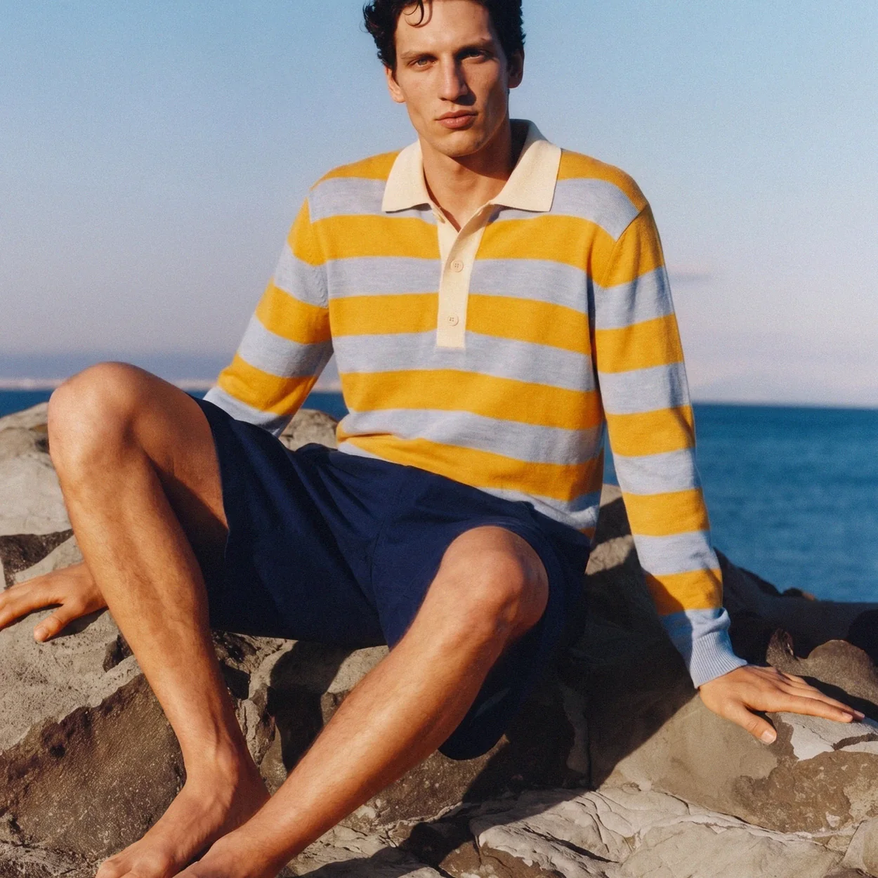 Striped Sheep Inc rugby shirt in yellow and blue worn by the sea