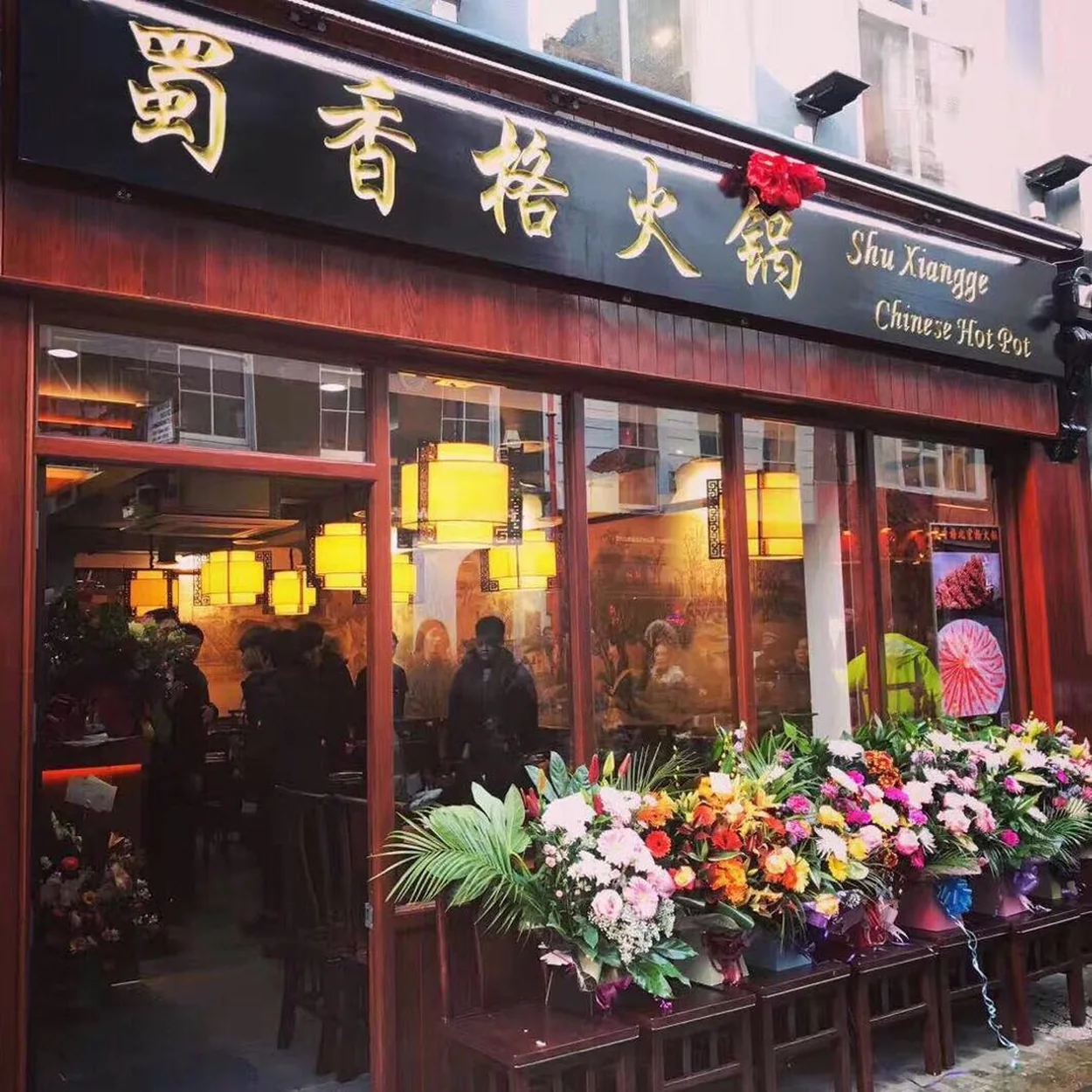 Lantern-lit frontage of Shu Xiang Ge hotpot restaurant dressed with flowers in Chinatown