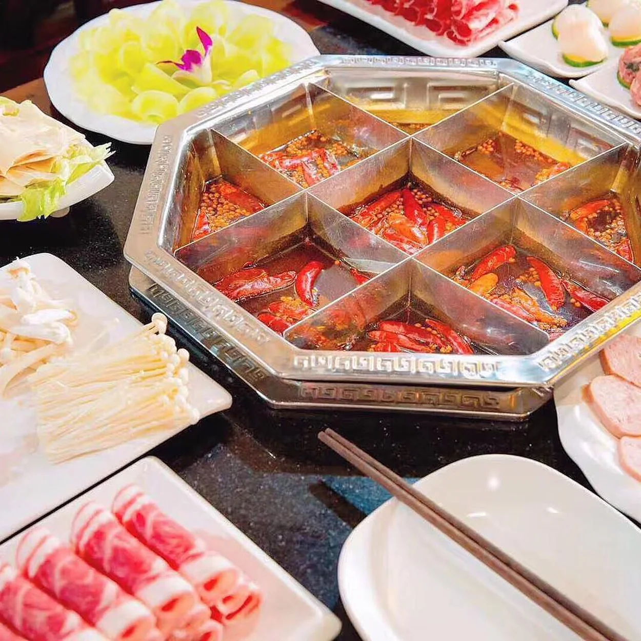 Table of hotpot platters around a divided broth pot at Shu Xiang Ge