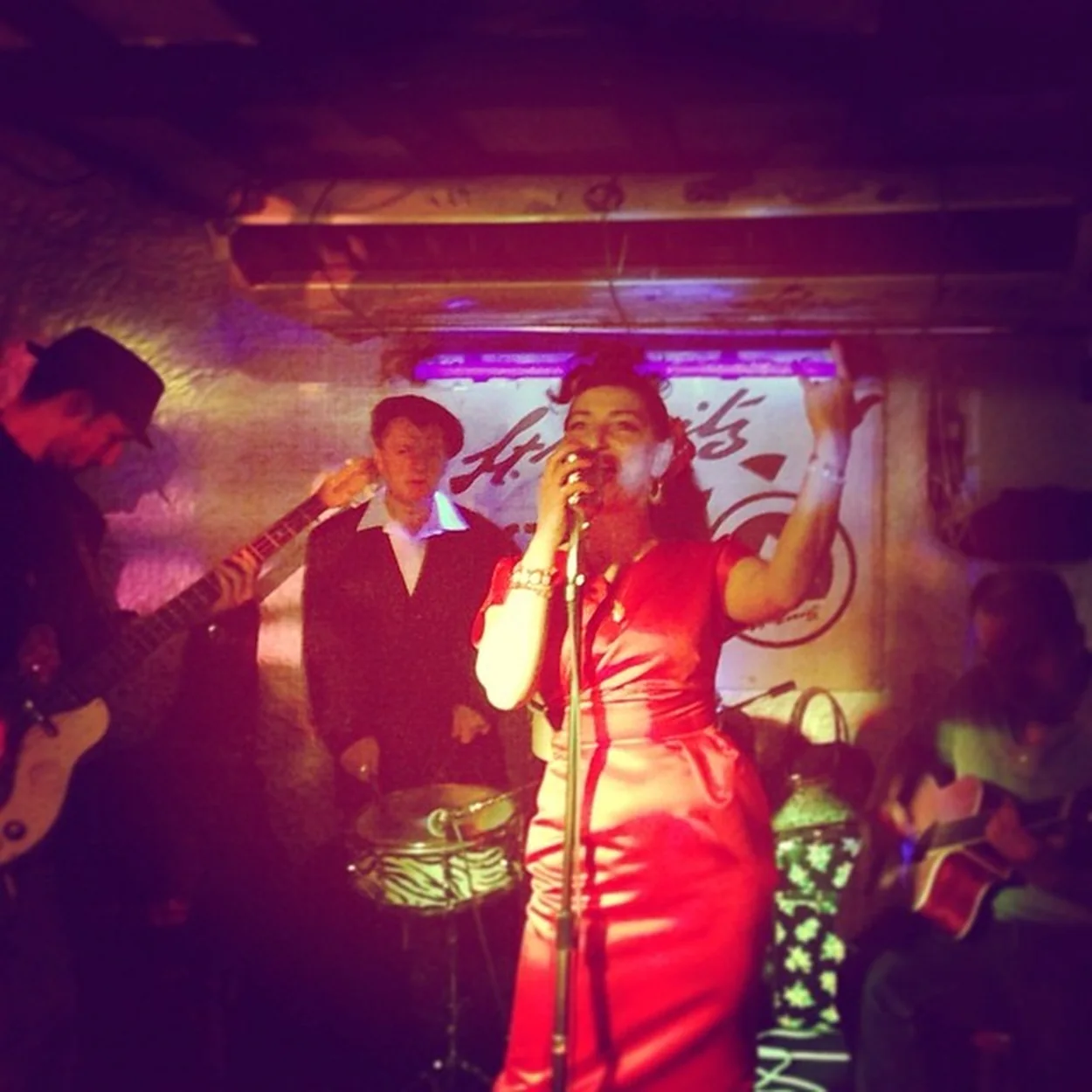 Singer in a red dress performing on the basement stage at the St Moritz Club on Wardour Street