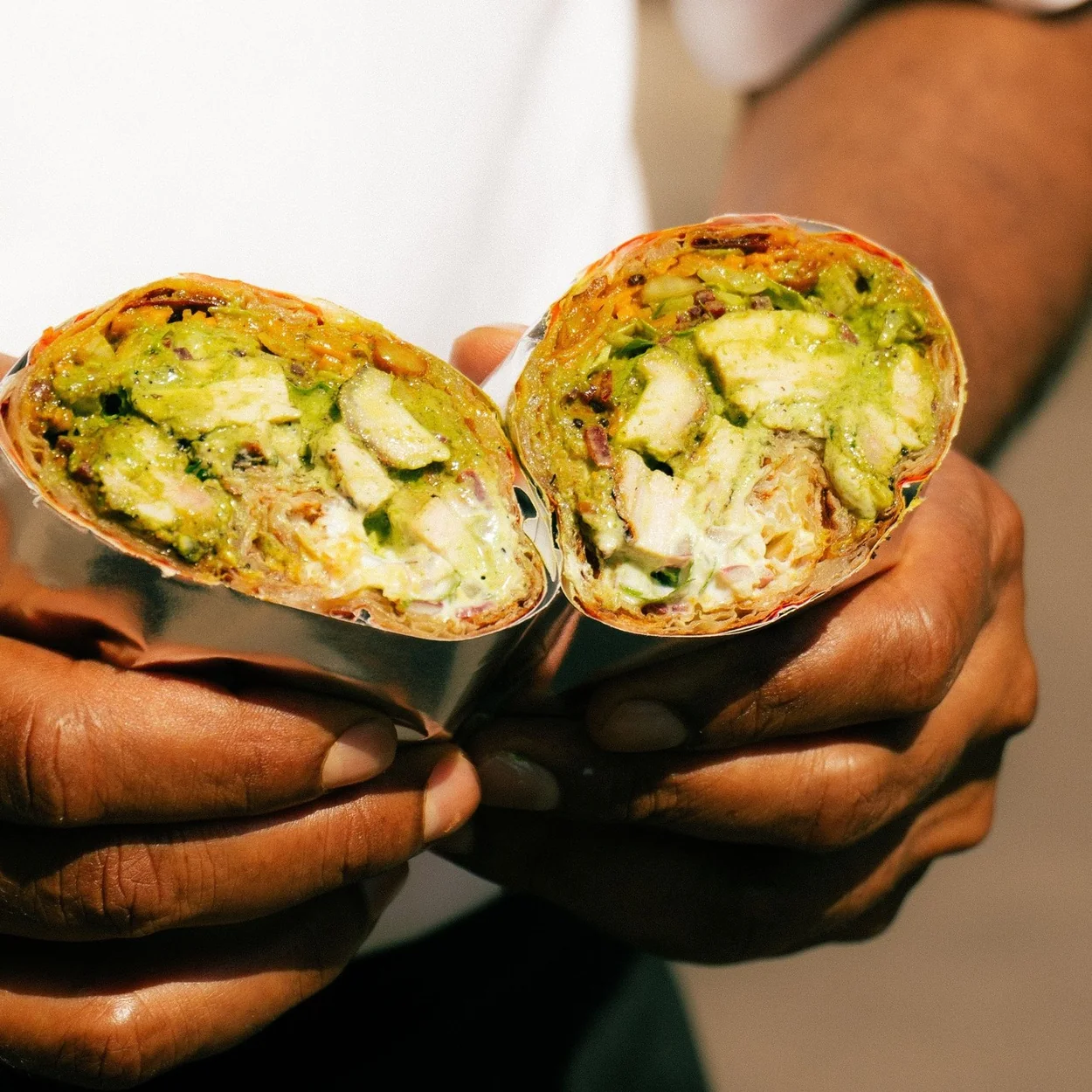 Halved vegetable wrap showing avocado and chutney at Tamila Soho