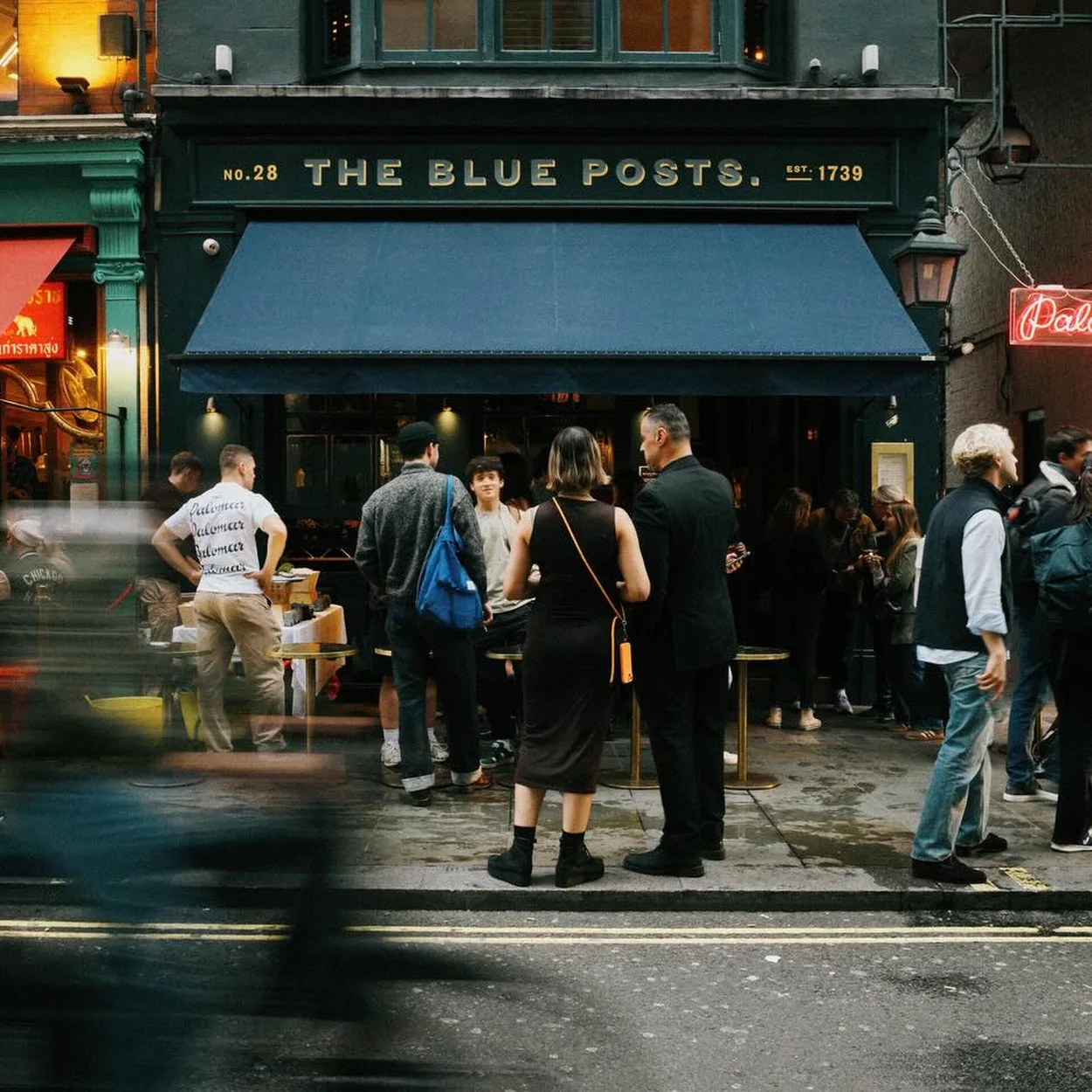Evening crowd outside The Blue Posts on the corner of Rupert Street in Soho