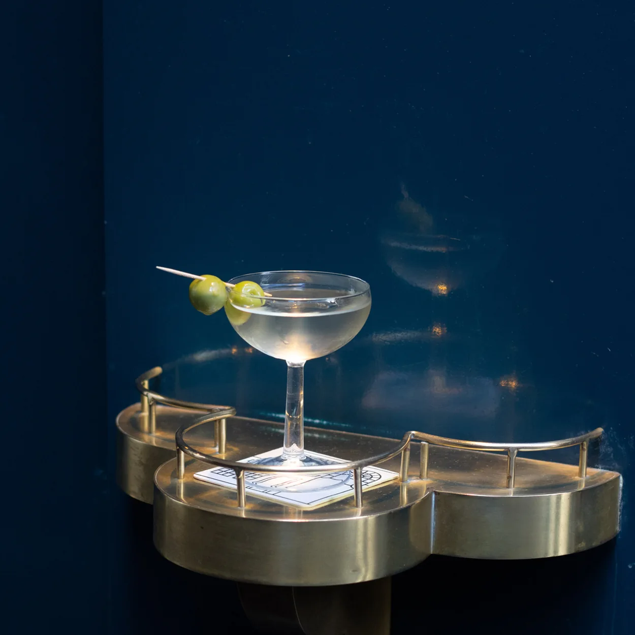 Martini with olives on a brass shelf at The Mulwray above The Blue Posts