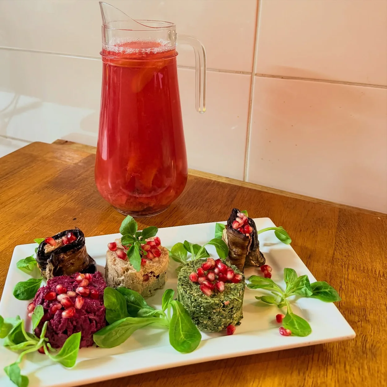 Georgian pkhali platter with pomegranate beside a jug of house lemonade at Violet's in Soho