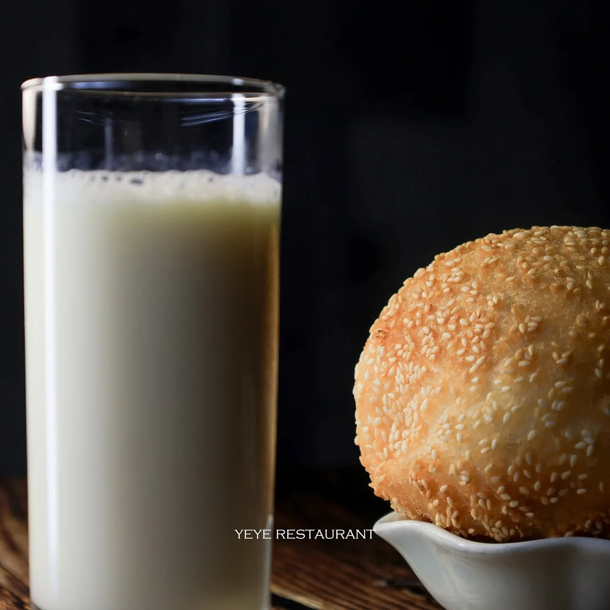 Fresh soy milk beside a sesame bun at YeYe Noodle and Dumpling, Wardour Street