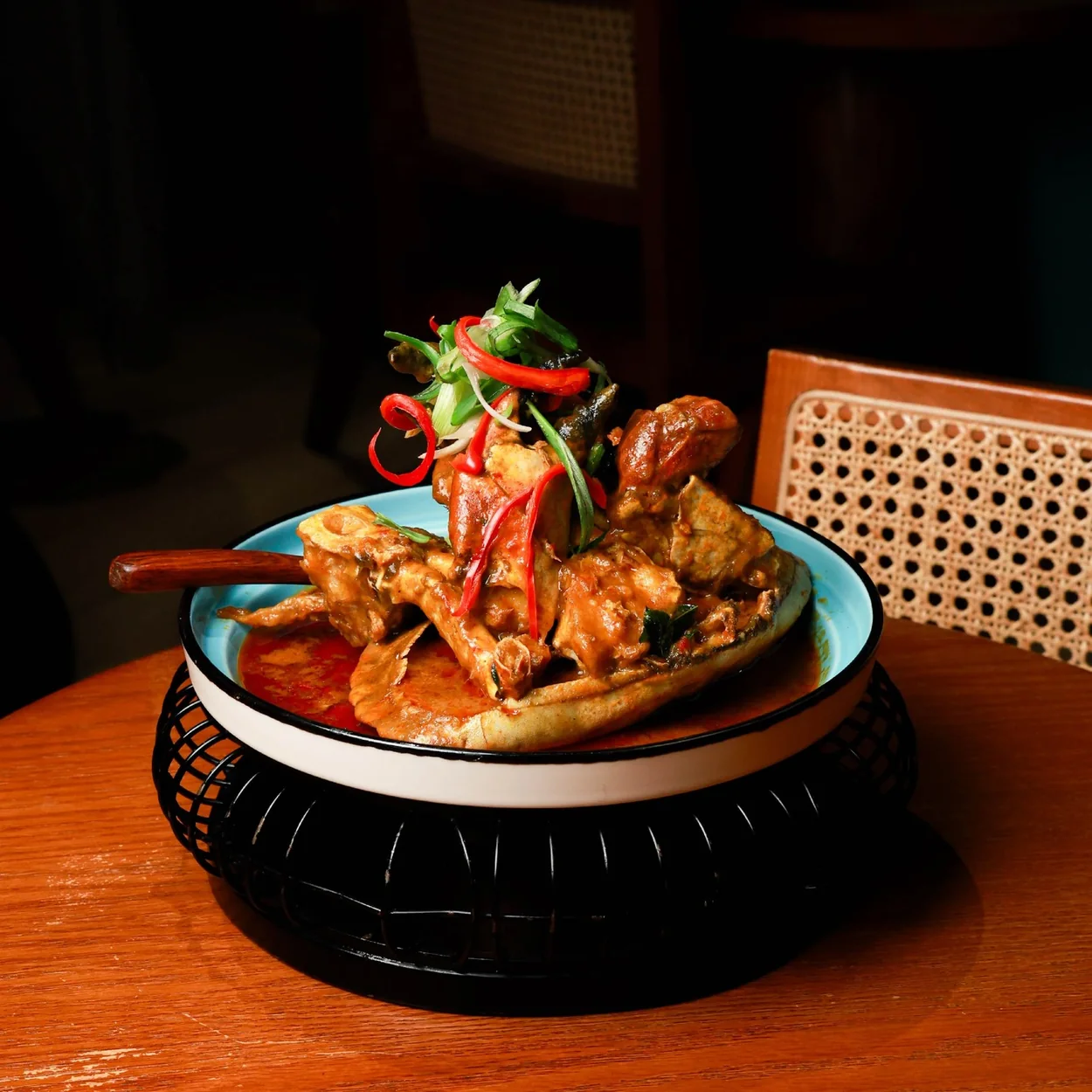 Chilli crab served in a clay pot on a rattan stand at Yiqi, Chinatown London
