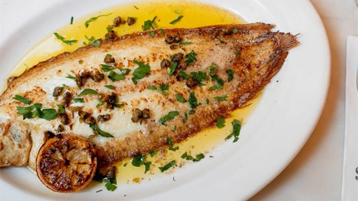 Pan-fried sole with capers, parsley and a charred lemon half served at The Seafood Bar on Dean Street, Soho